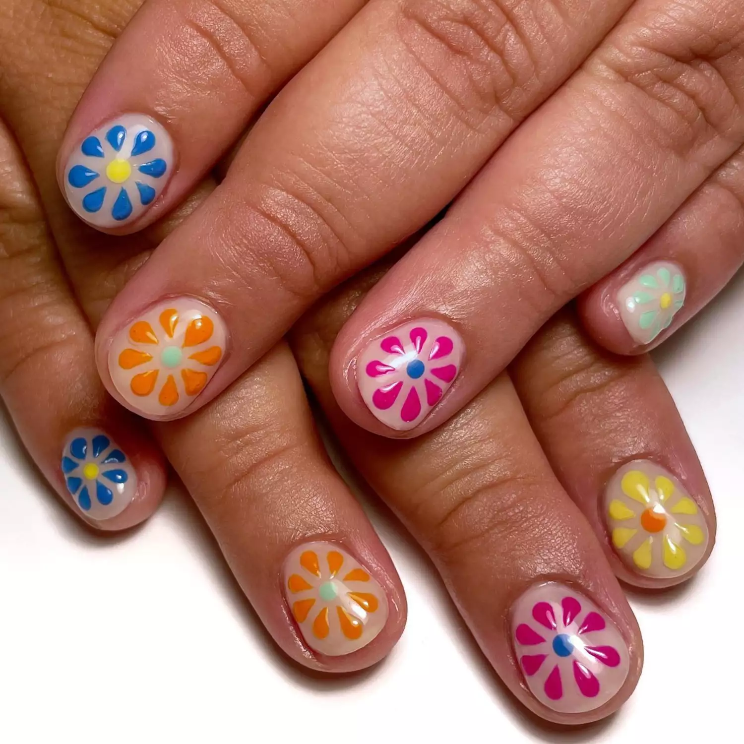 nails with 3d flowers in shades of pink, blue, orange, yellow